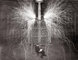 A Revolutionary Moment in Electrical Engineering Nikola Tesla sitting in front of a Tesla coil with electrical arcs